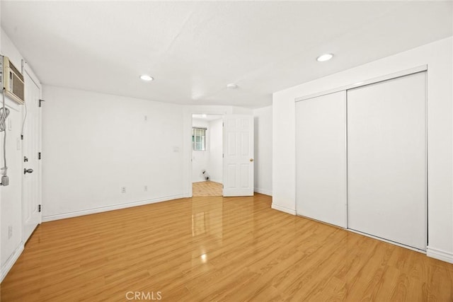 unfurnished bedroom with a closet and light hardwood / wood-style floors