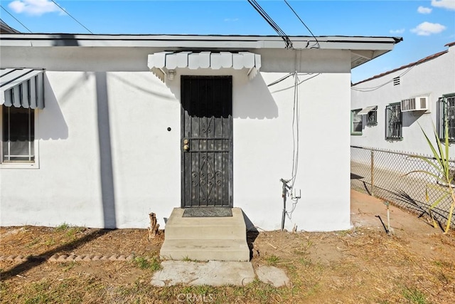 view of exterior entry featuring an AC wall unit