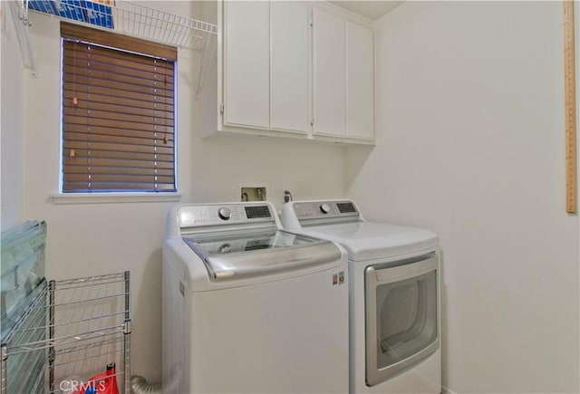 washroom with cabinets and washing machine and clothes dryer