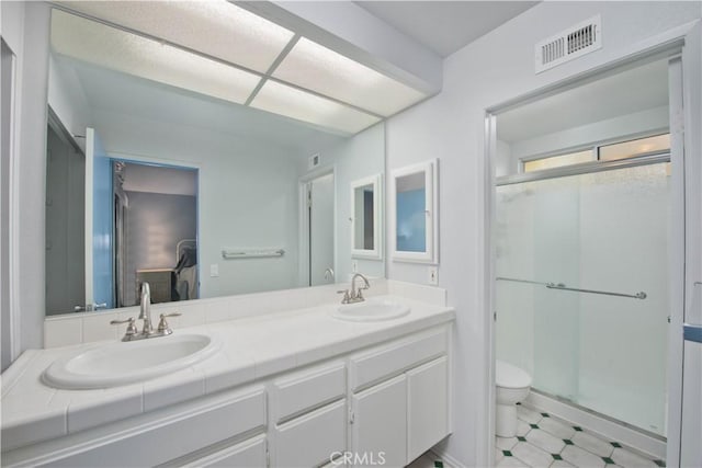 bathroom featuring vanity, toilet, and a shower with door