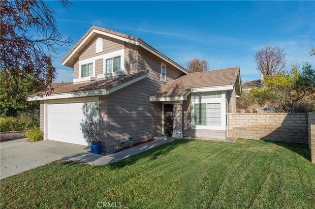 view of front of home with a front yard and a garage