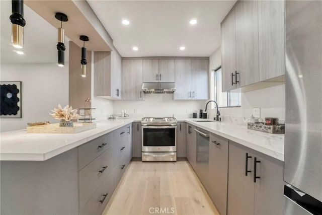 kitchen with sink, light hardwood / wood-style flooring, hanging light fixtures, gray cabinetry, and stainless steel appliances