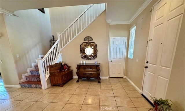 entryway with crown molding and light tile patterned floors