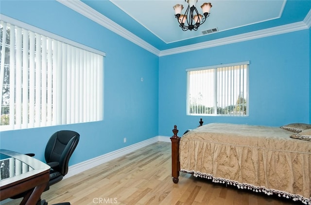 bedroom with wood-type flooring, ornamental molding, and a notable chandelier