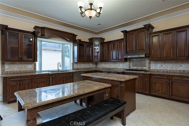 kitchen with light stone countertops, dark brown cabinetry, an inviting chandelier, and a kitchen island