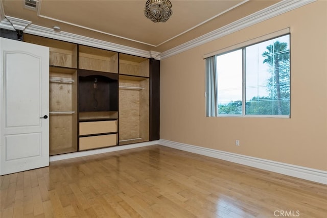 spare room with light hardwood / wood-style flooring and crown molding