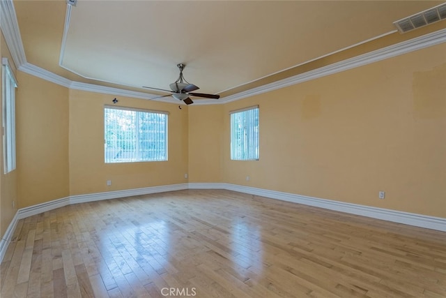 spare room with ceiling fan, crown molding, and light wood-type flooring