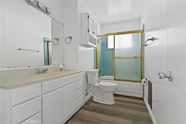 full bathroom with toilet, hardwood / wood-style flooring, vanity, and shower / bath combination with glass door