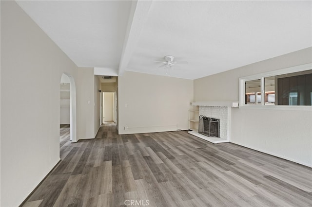 unfurnished living room featuring ceiling fan, dark hardwood / wood-style floors, and beamed ceiling