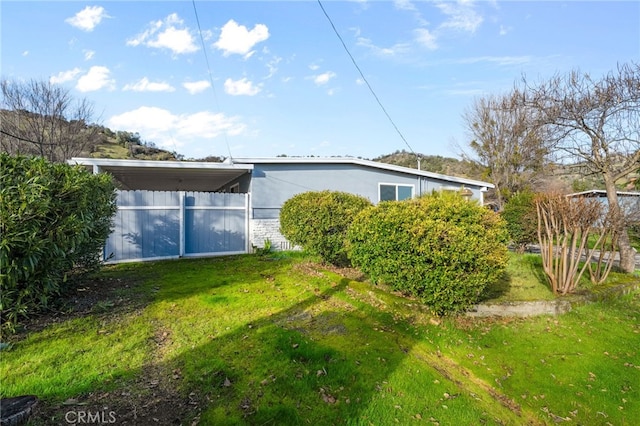 view of home's exterior featuring a carport and a lawn