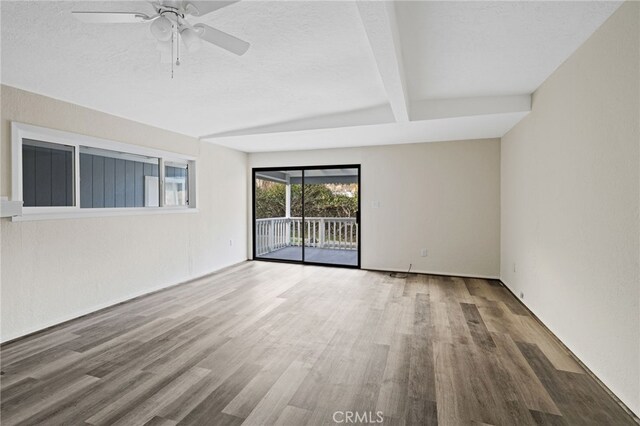 unfurnished room with a textured ceiling, ceiling fan, beam ceiling, and hardwood / wood-style floors