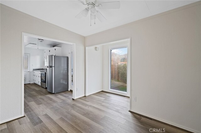 interior space with ceiling fan, ornamental molding, and light hardwood / wood-style flooring