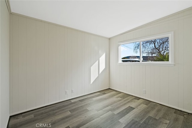 empty room with wood walls and hardwood / wood-style flooring