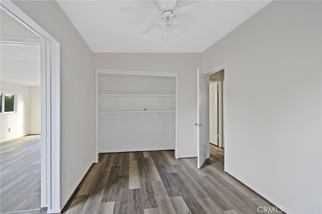 unfurnished bedroom with ceiling fan, a closet, and dark hardwood / wood-style flooring