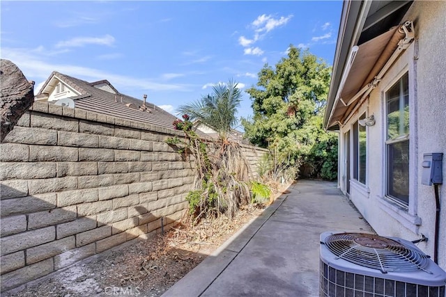 view of side of property with a patio area and central AC