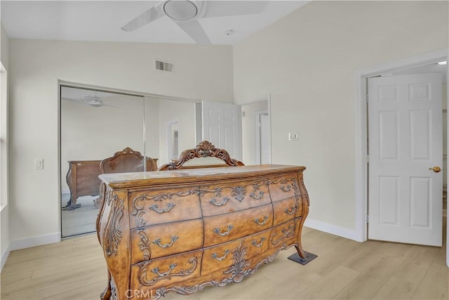 bedroom with ceiling fan, a closet, light wood-type flooring, and lofted ceiling