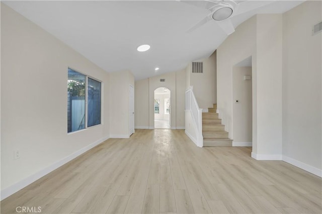 unfurnished living room with ceiling fan, vaulted ceiling, and light hardwood / wood-style floors