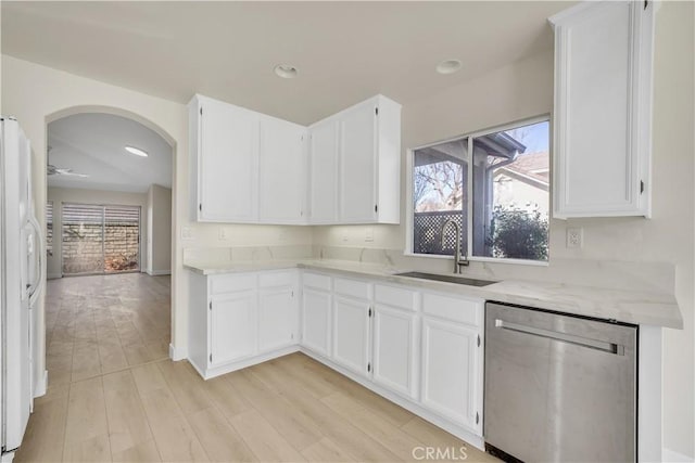 kitchen with stainless steel dishwasher, white cabinets, sink, and white refrigerator