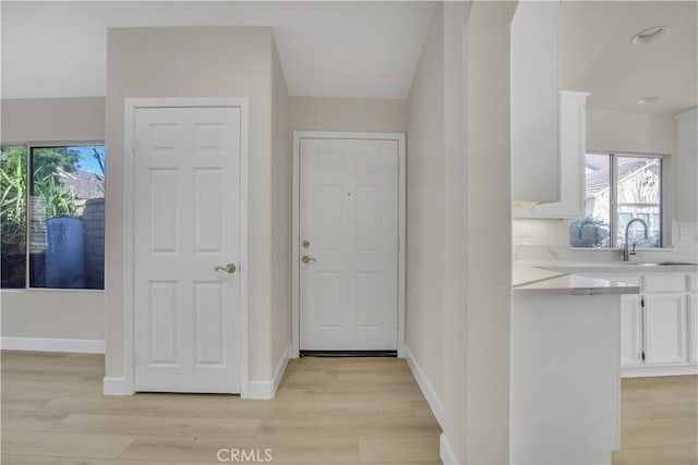 entryway featuring sink and light hardwood / wood-style flooring