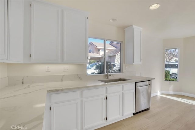 kitchen with sink, white cabinets, stainless steel dishwasher, and a healthy amount of sunlight