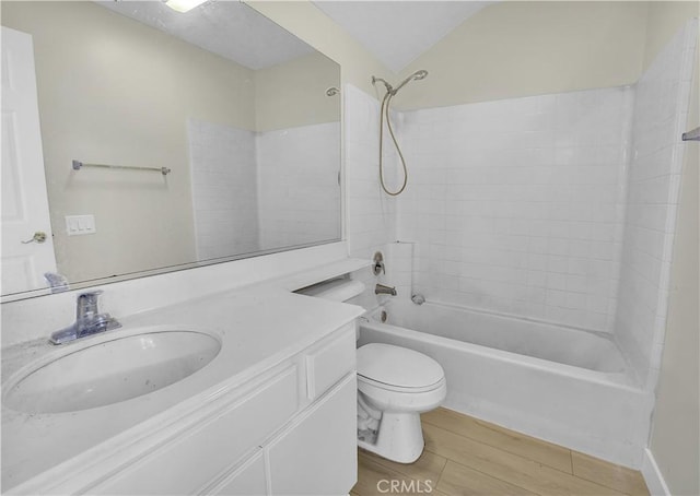 full bathroom with washtub / shower combination, vanity, toilet, and vaulted ceiling