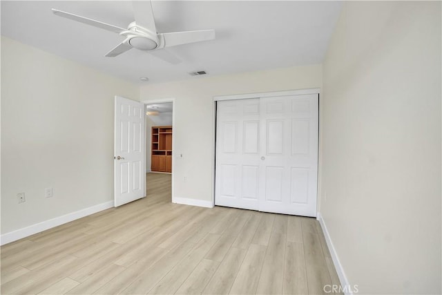 unfurnished bedroom with a closet, light hardwood / wood-style flooring, and ceiling fan