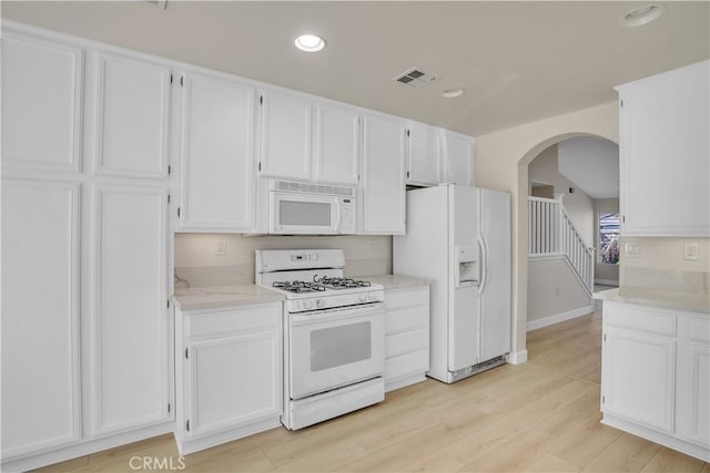 kitchen featuring white appliances, white cabinetry, and light hardwood / wood-style floors