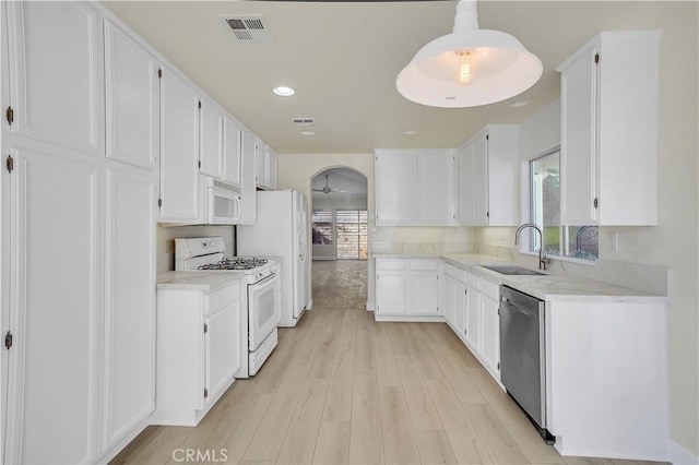 kitchen featuring ceiling fan, sink, white appliances, and white cabinetry