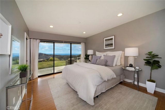 bedroom featuring access to exterior and hardwood / wood-style flooring