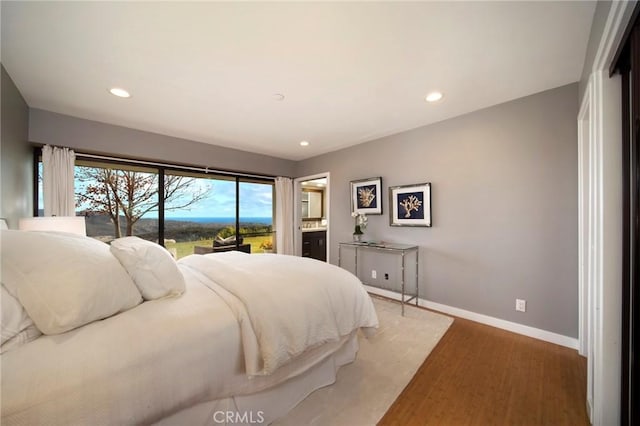 bedroom featuring ensuite bathroom and hardwood / wood-style floors