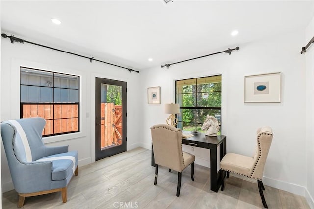 office space with light hardwood / wood-style floors and a barn door