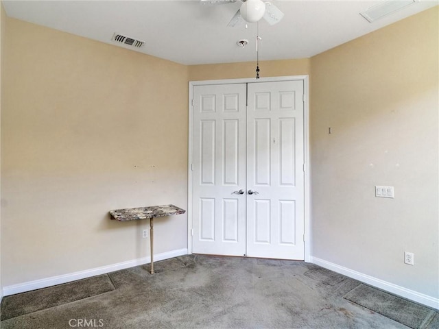 unfurnished bedroom featuring ceiling fan, a closet, and carpet flooring