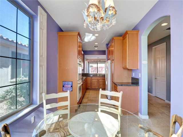 tiled dining space featuring an inviting chandelier