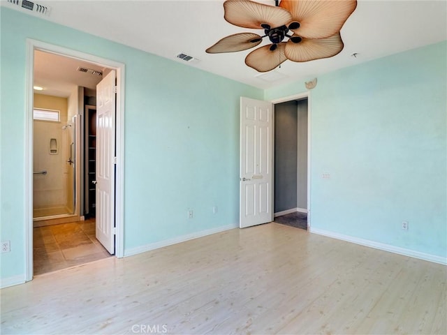 unfurnished bedroom with ceiling fan, ensuite bathroom, and light hardwood / wood-style flooring