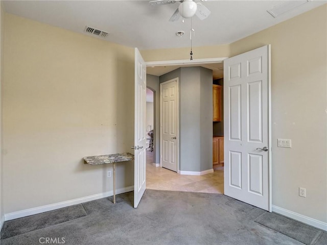 unfurnished bedroom featuring light carpet and ceiling fan