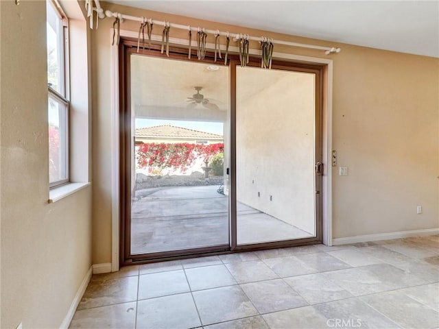 doorway to outside with ceiling fan and light tile patterned floors