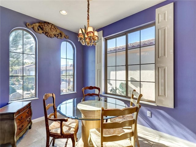 dining area featuring light tile patterned flooring and an inviting chandelier