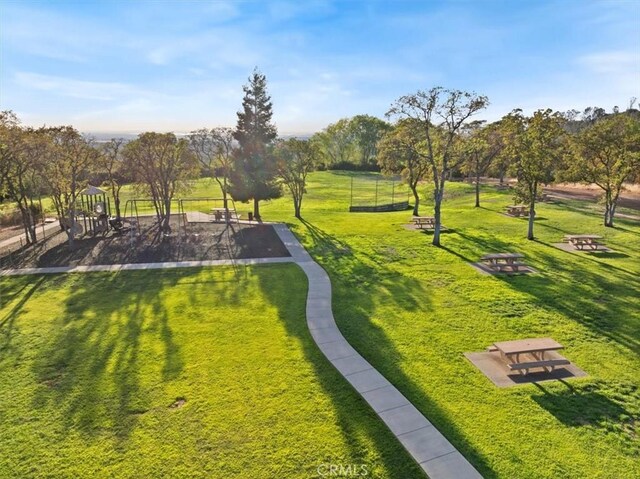 view of property's community featuring a lawn and a playground