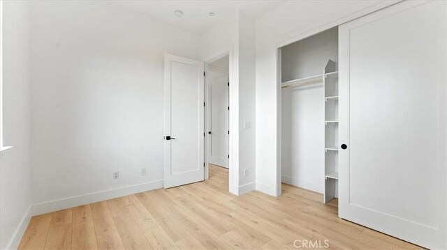 unfurnished bedroom with a closet and light hardwood / wood-style floors