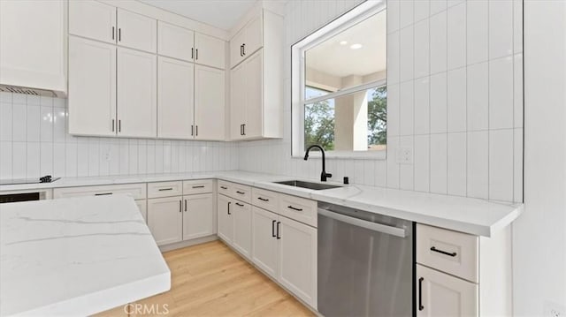 kitchen with white cabinetry, light hardwood / wood-style floors, sink, light stone counters, and stainless steel dishwasher