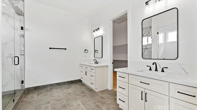 bathroom featuring a shower with shower door, vanity, and tile patterned flooring