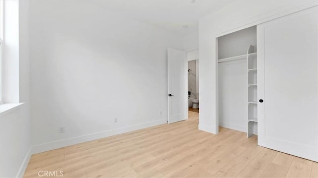 unfurnished bedroom featuring light wood-type flooring and a closet