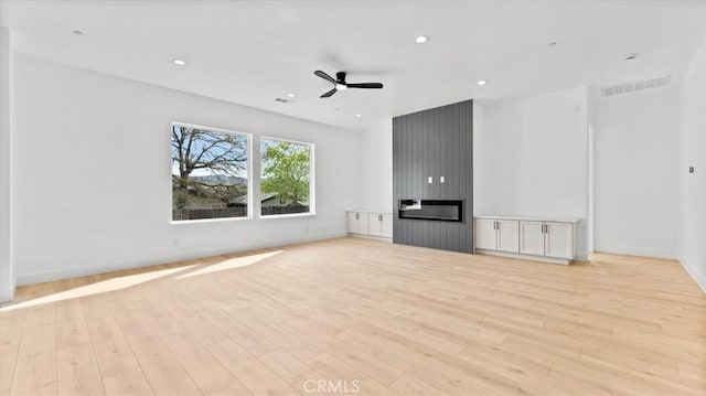 unfurnished living room with ceiling fan and light hardwood / wood-style flooring