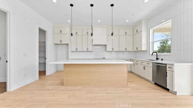 kitchen with a kitchen island, stainless steel dishwasher, white cabinets, and hanging light fixtures