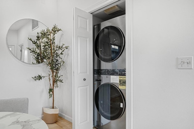 clothes washing area with stacked washer and dryer