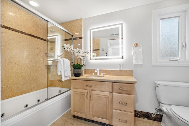 full bathroom with shower / bath combination with glass door, vanity, and toilet