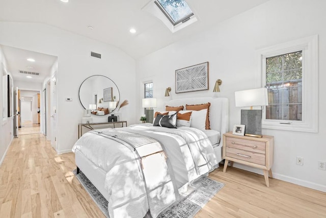 bedroom featuring light wood-type flooring and vaulted ceiling with skylight