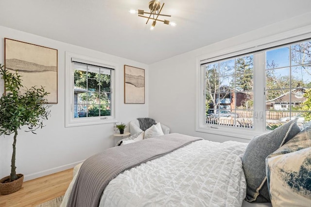 bedroom with hardwood / wood-style flooring and an inviting chandelier