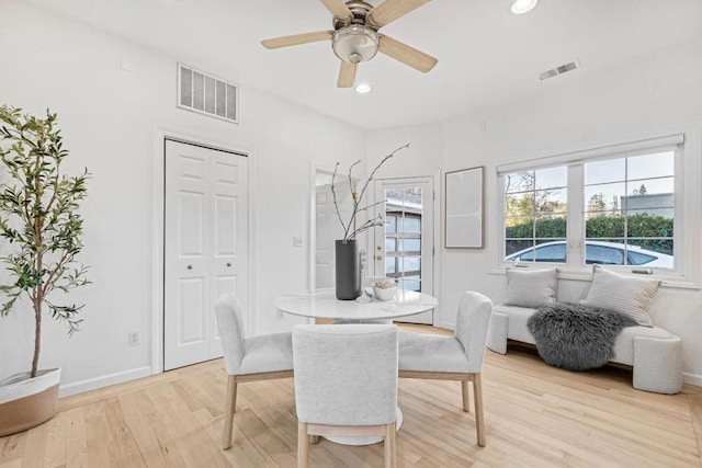 dining area with ceiling fan and light wood-type flooring