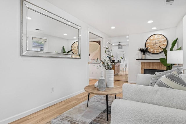 living room featuring hardwood / wood-style flooring and a tiled fireplace